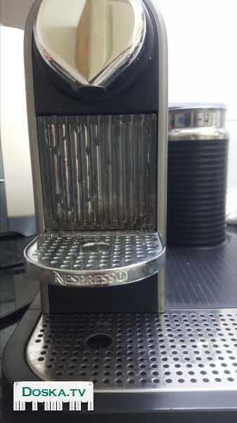 Кофемашина Nespresso с капсулами и стаканом для молока.